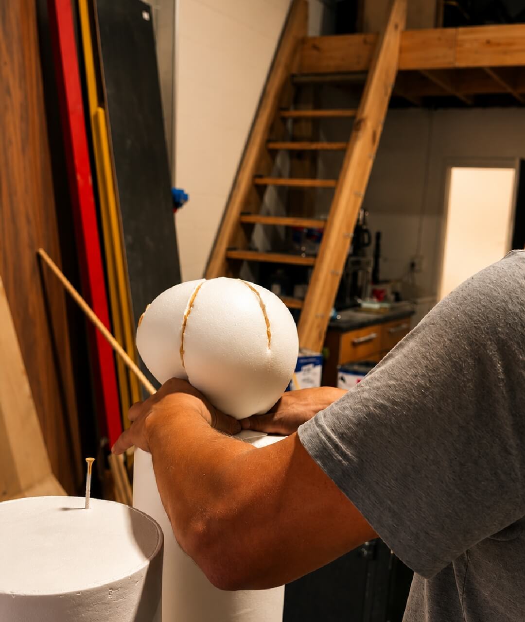 Custom Event Prop Stage Design Fabrication Technician assembling foam structures inside a production warehouse workshop, highlighting custom stage prop design, specialized scenic elements, and creative solutions for premium audio visual event rentals.